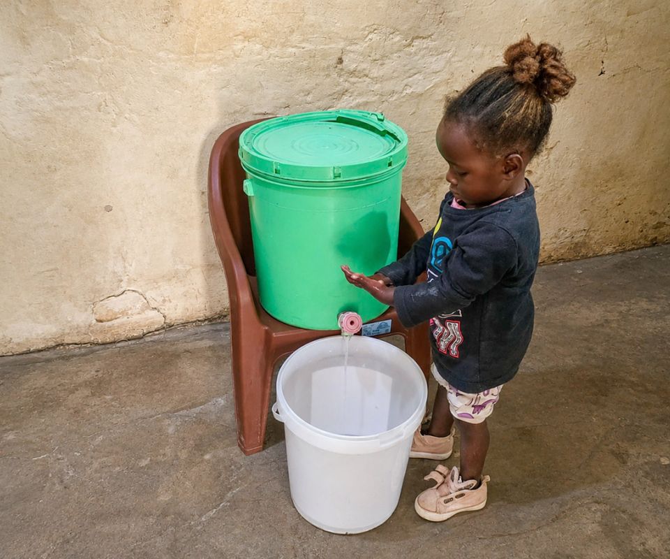 young girl washes hands