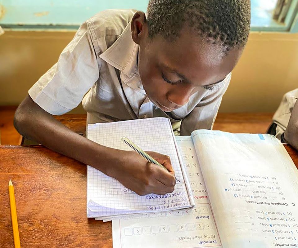 young boy working in class
